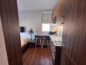 a small kitchen with a sink and a bed in a room at London Studio Retreat - Colney Hatch Lane in London