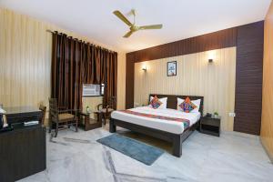 ein Schlafzimmer mit einem Bett und einem Deckenventilator in der Unterkunft FabHotel Next Home Prime in Gurgaon