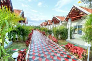 a walkway in front of a house with red flowers at Coorg Crown Palace Resort kushalnagar in Jāmb