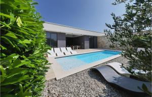 a swimming pool with white chairs and a house at Villa K2 in Zadar