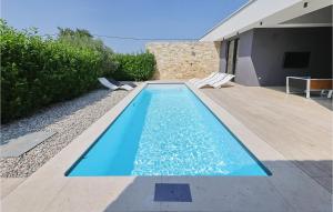 a swimming pool with two chairs next to a house at Villa K2 in Zadar +34 photos