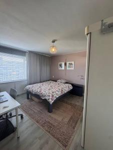 Un dormitorio con una cama y una mesa y una ventana. en Ladies only! neat cozy room, great loc in Schiedam, en Schiedam