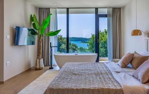 una camera da letto con vasca e ampia finestra di Stunning Home In Pomer With Sauna a Pomer