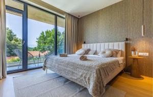 una camera da letto con un letto grande e una grande finestra di Stunning Home In Pomer With Sauna a Pomer