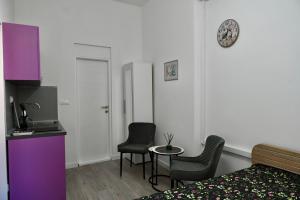 a hotel room with a bed and two chairs and a table at The Bell Studio in Sarajevo +2 photos