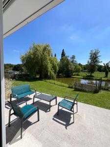 a group of three chairs and a picnic table on a patio at La petite maison in Plélan-le-Petit