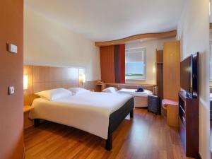 a hotel room with two beds and a television at ibis Stuttgart Airport Messe in Leinfelden-Echterdingen