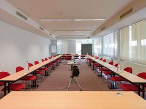 an empty classroom with desks and red chairs at ibis Stuttgart Airport Messe in Leinfelden-Echterdingen