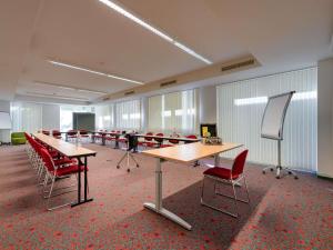 a conference room with tables and red chairs at ibis Stuttgart Airport Messe in Leinfelden-Echterdingen