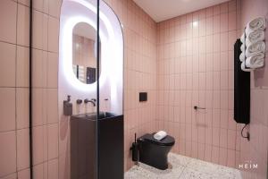 a bathroom with a toilet and a glass shower at Malva at The Heim Residences in Manchester