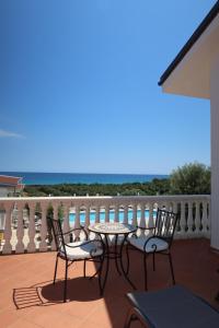 a patio with a table and chairs on a balcony at La Corte dei Sabatini in Pietrapaola