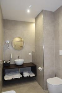 a bathroom with a sink and a toilet and a mirror at La Corte dei Sabatini in Pietrapaola