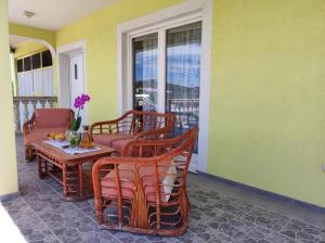 a porch with chairs and a table and a window at Apartment Duje Dazlina in Dazlina