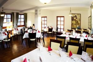 a restaurant with white tables and chairs with red napkins at Figula Vendégház in Balatonfüred