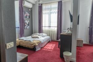 a bedroom with a bed and a window with purple curtains at Vila 18 Hotel Boutique in Bucharest