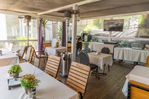 a restaurant with tables and chairs and a tv at Vila 18 Hotel Boutique in Bucharest