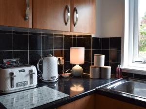 a kitchen with a counter top with a toaster and a lamp at Tree Tops in Crieff