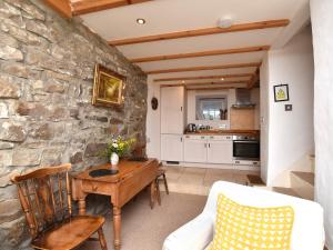 a living room with a table and a stone wall at 1 Bed in Richmond 36769 in Reeth