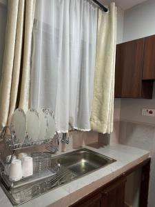 eine Küchentheke mit Spüle und Fenster in der Unterkunft Akombe homestay-Makasembo in Kisumu