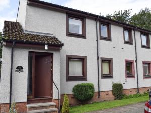 a white house with brown doors and windows at Tree Tops in Crieff