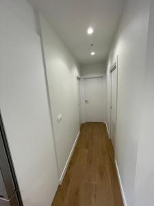 Apartamento PLAYA DE SALGUEIRON في كانجاس دي مورازو: ممر فارغ بجدران بيضاء وارضيات خشبية +14 صورة