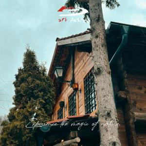 a sign on the side of a building next to a tree at Whispering Pines Villa in Peje +6 photos
