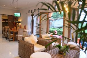 a living room with wicker chairs and a table at Villa Jogja Tropical in Yogyakarta
