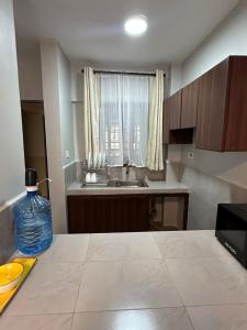 eine kleine Küche mit Spüle und Fenster in der Unterkunft Akombe homestay-Makasembo in Kisumu + 2 Fotos
