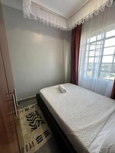 ein kleines Schlafzimmer mit einem Bett und einem Fenster in der Unterkunft Akombe homestay-Makasembo in Kisumu