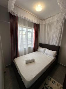 ein Schlafzimmer mit einem großen Bett mit Fenster in der Unterkunft Akombe homestay-Makasembo in Kisumu