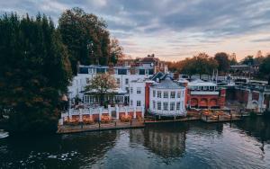 a group of buildings next to a body of water at The Mitre, Hampton Court in Kingston upon Thames