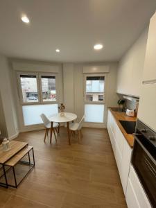 Apartamento PLAYA DE SALGUEIRON في كانجاس دي مورازو: مطبخ مع طاولة وطاولة وكراسي