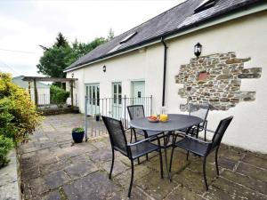 a patio with a table and chairs in front of a building at 3 Bed in South Molton HBEER in Warkleigh