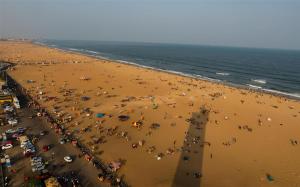 una multitud de personas en una playa con sombrillas en Radisson Blu Hotel Chennai City Centre, en Chennai
