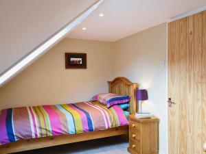 Old Rayne隆克罗夫特度假屋的卧室里有一张床，床上铺着条纹毯子