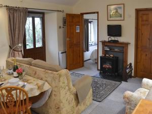 a living room with a couch and a table and a fireplace at The Smithy in Brentor