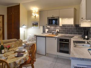 a kitchen and living room with a table and a couch at The Smithy in Brentor