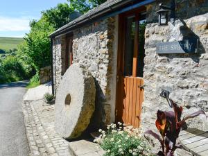 a stone building with a large rock in front of it at The Smithy in Brentor