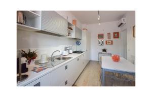 ファレルナにある3 Bedroom Beautiful Home In Falernaの白いキャビネットとシンクとテーブルのあるキッチン