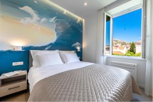 a bedroom with a large bed and a large window at Adam and Cupid in Dubrovnik