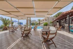 SellíaにあるSouda Bay Apartmentsのテーブルと椅子とプールのあるパティオ