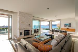 a living room with a couch and a fireplace at Paradise Beachfront Villa Athenian Riviera in Aghia Marina
