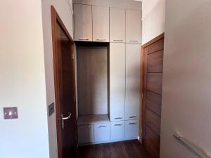 a closet with white cabinets and a wooden door at Cozy Studio in North London in London