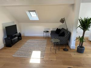 a living room with a couch and a tv at Hope Valley - Studio - Sleeps 2 - Parking in Froggatt