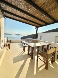 a patio with tables and a view of the ocean at Petradi Studios & Villa in Aegiali