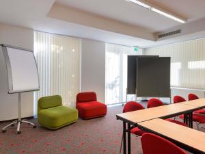 a room with a classroom with chairs and a screen at ibis Stuttgart Airport Messe in Leinfelden-Echterdingen