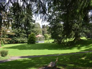 a park with a gazebo and a bench in the grass at Tree Tops in Crieff