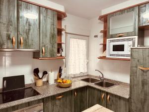 una cocina con fregadero y microondas en O sete dos Soportais, en Pontevedra