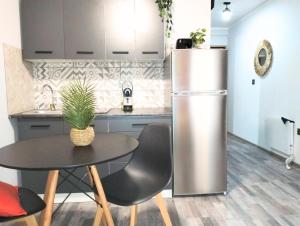 a kitchen with a table and a stainless steel refrigerator at At Piazza Erbe free parking Residenza Santa Anastasia in Verona