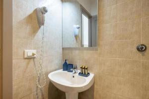 un bagno con lavandino e specchio di Next Stop Vatican Guest House a Roma